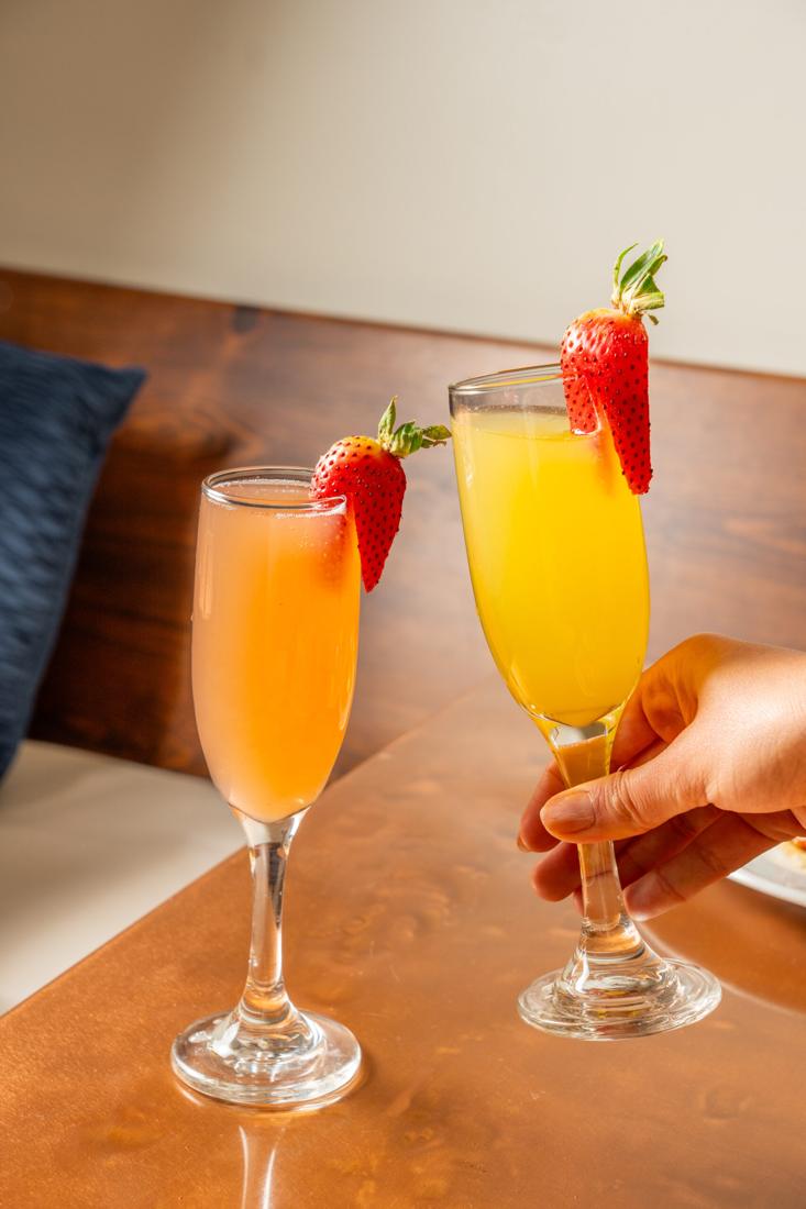 Two mimosas garnished with strawberries